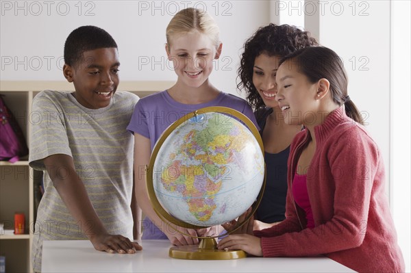 Portrait of teenage students (14-15, 16-17) with globe. 
Photo: Rob Lewine