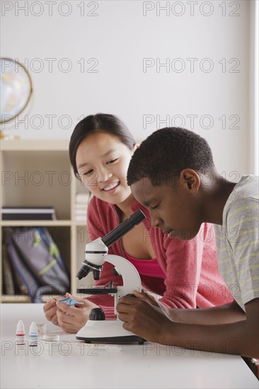 Teenage students (14-15) working with microscope. 
Photo: Rob Lewine