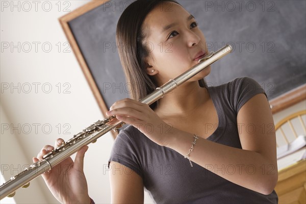 Teenage girl (14-15) playing flute. 
Photo : Rob Lewine