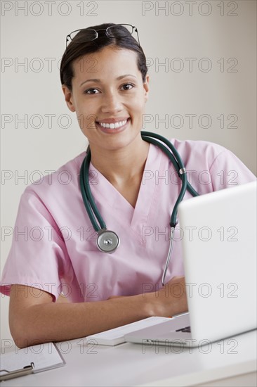 Portrait of female doctor working on laptop. 
Photo : Rob Lewine