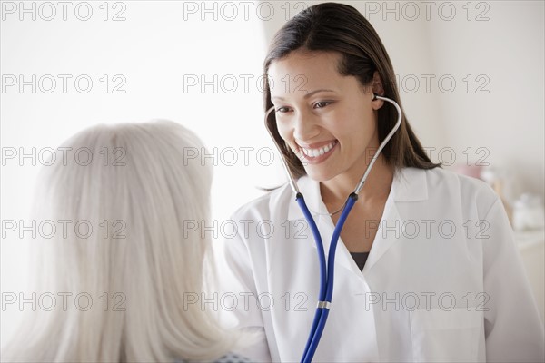 Young doctor examining senior patient. 
Photo : Rob Lewine