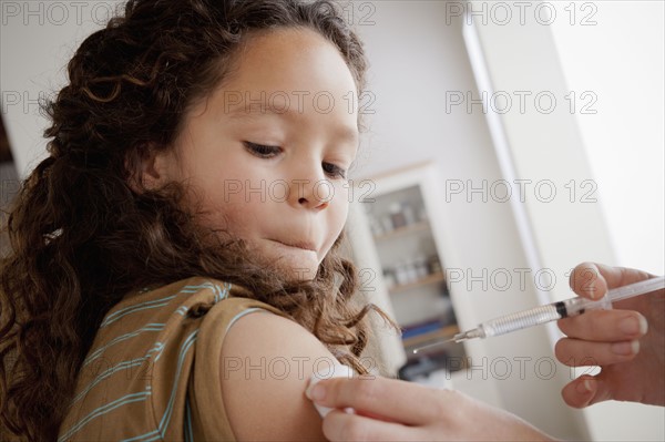 Girl (8-9) having vaccination. 
Photo: Rob Lewine