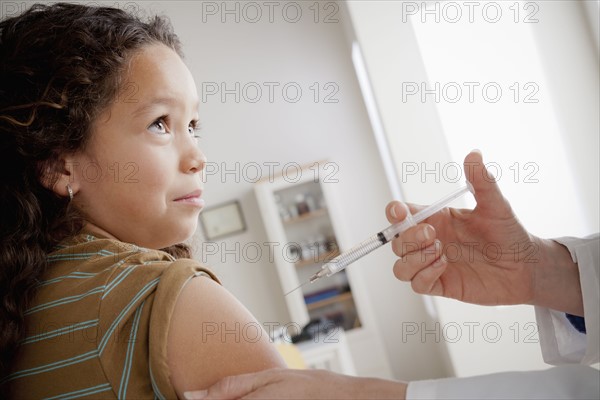 Girl (8-9) having vaccination. 
Photo: Rob Lewine