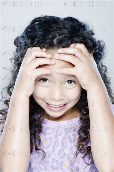 Portrait of smiling girl (8-9), studio shot. 
Photo: Rob Lewine