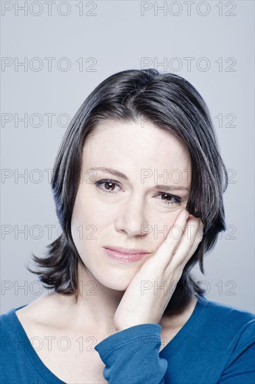 Portrait of worried mid adult woman, studio shot. 
Photo : Rob Lewine