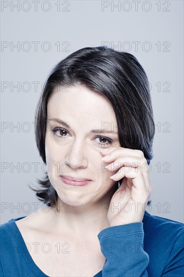 Mid adult woman crying, studio shot. 
Photo : Rob Lewine