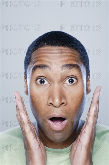 Young man looking surprised, studio shot. 
Photo : Rob Lewine