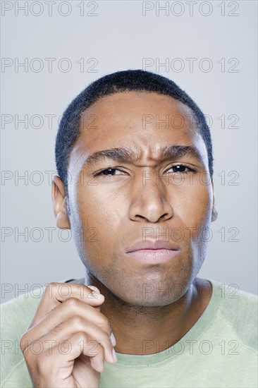 Portrait of confused young man, studio shot. 
Photo : Rob Lewine