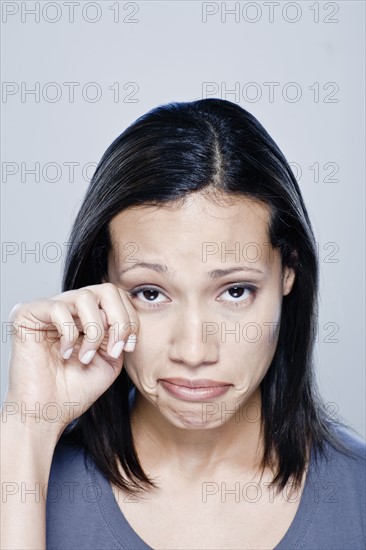 Portrait of young woman crying, studio shot. 
Photo : Rob Lewine