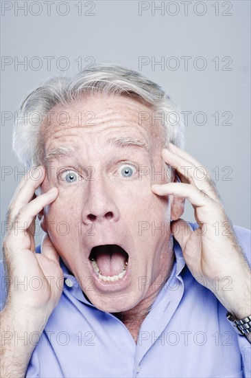 Portrait of scared senior man, studio shot. 
Photo : Rob Lewine