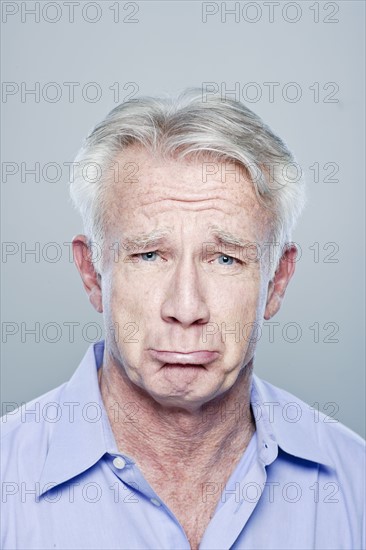 Portrait of senior man making sad face, studio shot. 
Photo : Rob Lewine