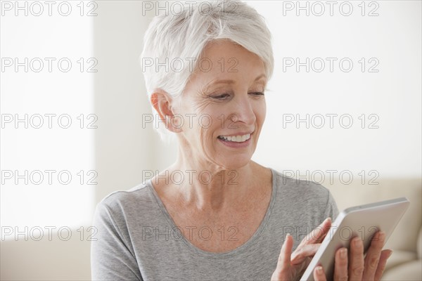 Smiling senior woman using digital tablet. 
Photo : Rob Lewine