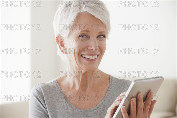 Smiling senior woman using digital tablet. 
Photo : Rob Lewine