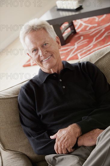 Portrait of smiling senior man sitting on sofa. 
Photo: Rob Lewine