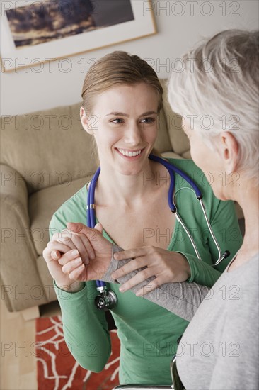 Young female nurse taking pulse of senior woman. 
Photo : Rob Lewine
