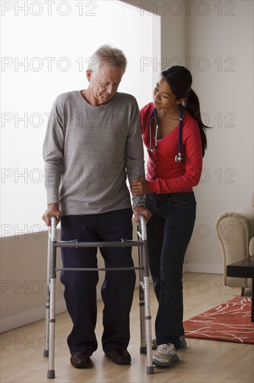 Young female nurse taking care of senior man with walker. 
Photo : Rob Lewine