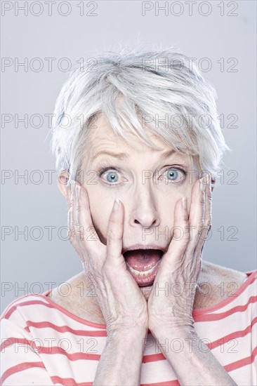 Portrait of shocked senior woman, studio shot. 
Photo : Rob Lewine