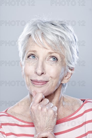 Portrait of smiling senior woman, studio shot. 
Photo : Rob Lewine