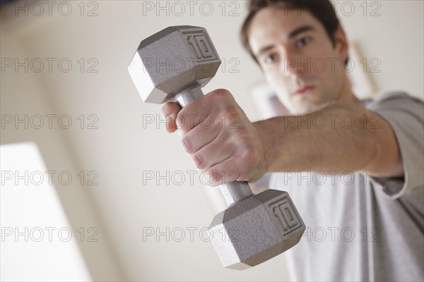 Young man exercising with dumbbell. 
Photo : Rob Lewine