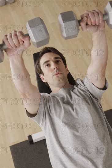 Young man exercising with dumbbell. 
Photo : Rob Lewine