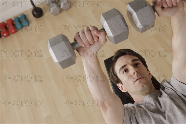 Young man exercising with dumbbell. 
Photo : Rob Lewine