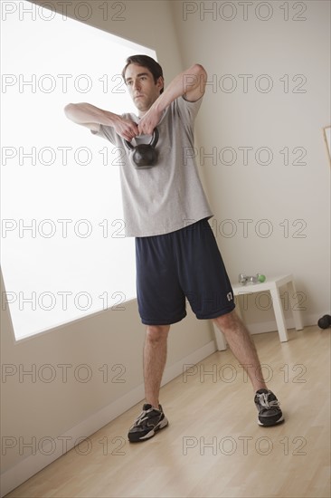 Young man exercising with weight. 
Photo : Rob Lewine