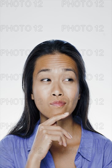 Portrait of confused young woman, studio shot. 
Photo : Rob Lewine