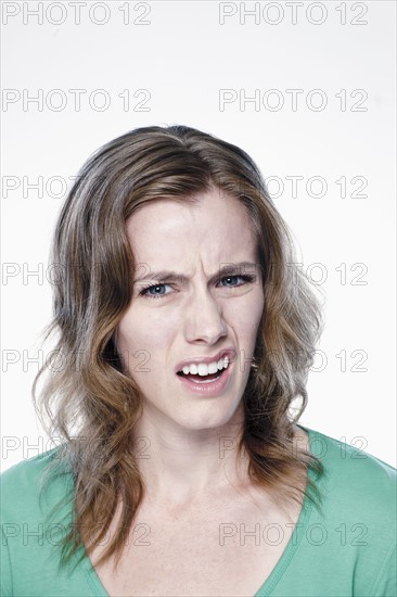 Portrait of confused young woman, studio shot. 
Photo : Rob Lewine