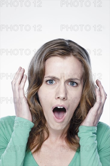 Portrait of shocked young woman, studio shot. 
Photo : Rob Lewine