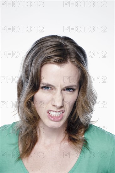 Portrait of angry young woman, studio shot. 
Photo : Rob Lewine
