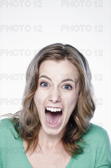 Portrait of screaming young woman, studio shot. 
Photo : Rob Lewine