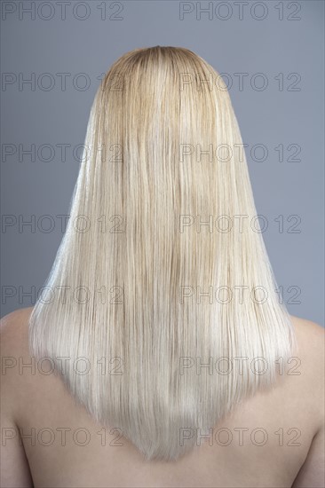 Rear view of woman with blonde hair, studio shot. 
Photo: Mark de Leeuw