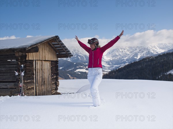 Austria, Maria Alm, Woman at top of mountain spreading arms. 
Photo : Mark de Leeuw