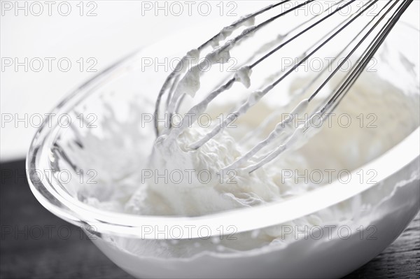 Whisking cream, studio shot. 
Photo : Elena Elisseeva