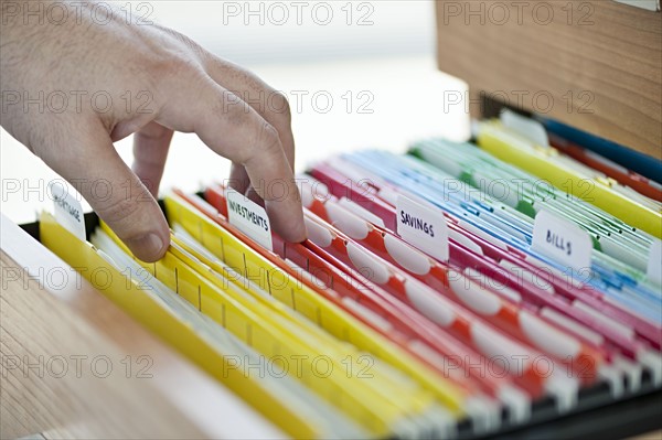 Hand searching in files drawer. 
Photo : Elena Elisseeva
