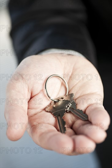 Home keys on hand, studio shot. 
Photo : Elena Elisseeva