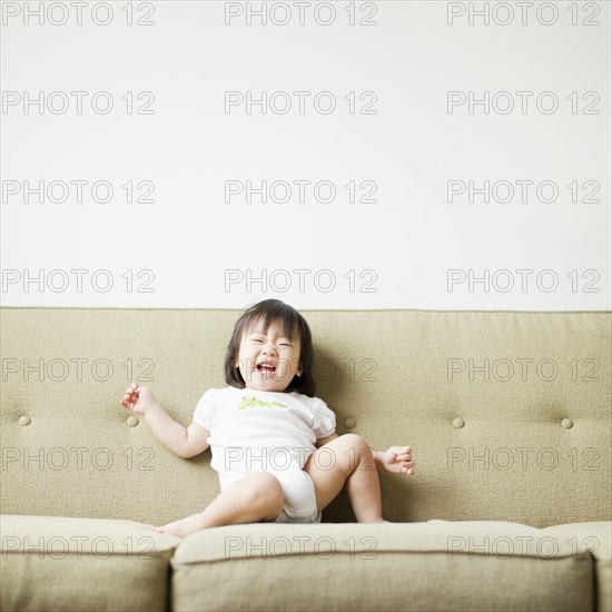 Baby girl (12-17 months) on sofa. 
Photo : Jessica Peterson