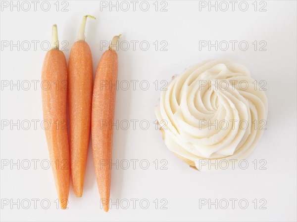 Carrots and muffin on white background, studio shot. 
Photo: Jessica Peterson