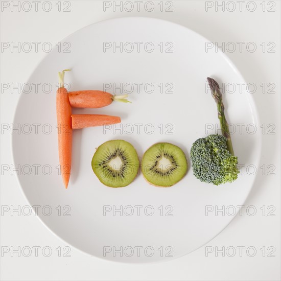 Plate with word 'food' made out of fruits and vegetables, studio shot. 
Photo : Jessica Peterson