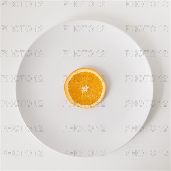 Slice of orange on plate, studio shot. 
Photo: Jessica Peterson