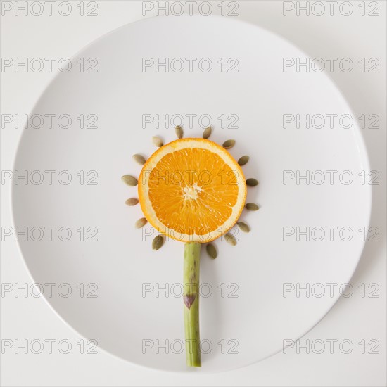 Sunflower made out of food on plate, studio shot. 
Photo : Jessica Peterson