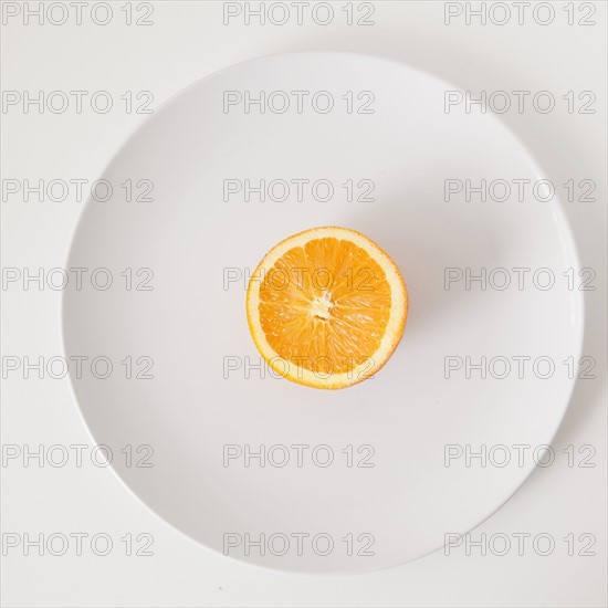 Half of orange on plate, studio shot. 
Photo: Jessica Peterson