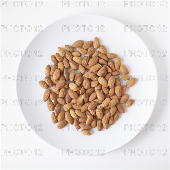 Almonds on plate, studio shot. 
Photo: Jessica Peterson