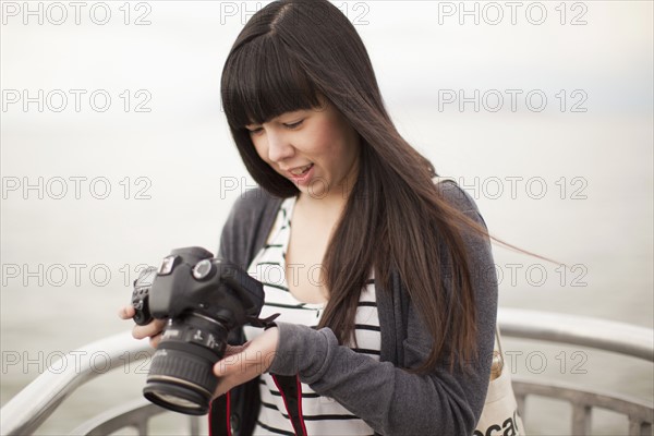 Young woman checking photos in camera. 
Photo : Jessica Peterson