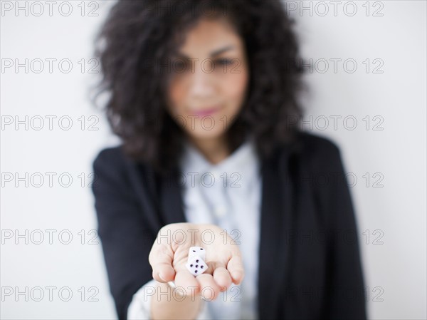 Young woman holding dices. 
Photo : Jessica Peterson