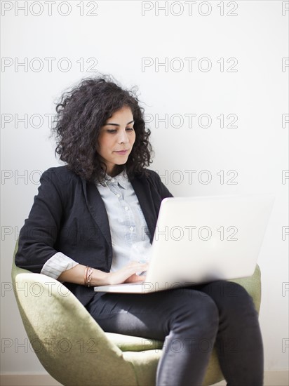 Studio shot of young woman using laptop. 
Photo : Jessica Peterson