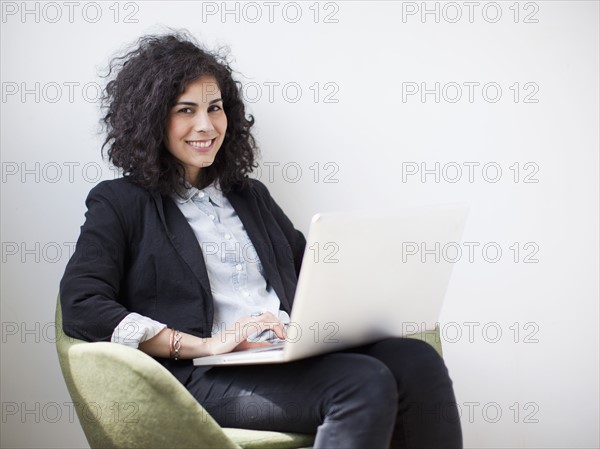 Studio shot of young woman using laptop. 
Photo: Jessica Peterson