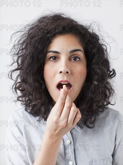 Young woman taking pill. 
Photo : Jessica Peterson