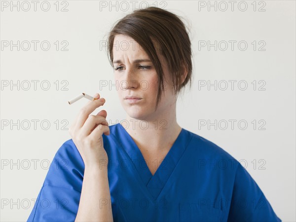 Young woman examining broke cigarette. 
Photo: Jessica Peterson