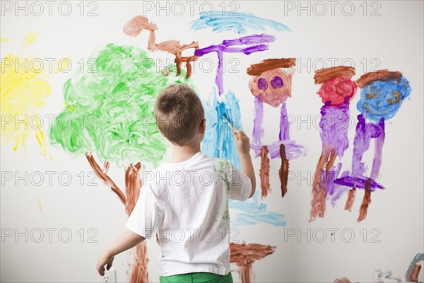 Toddler boy (2-3) painting on wall. 
Photo : Jessica Peterson